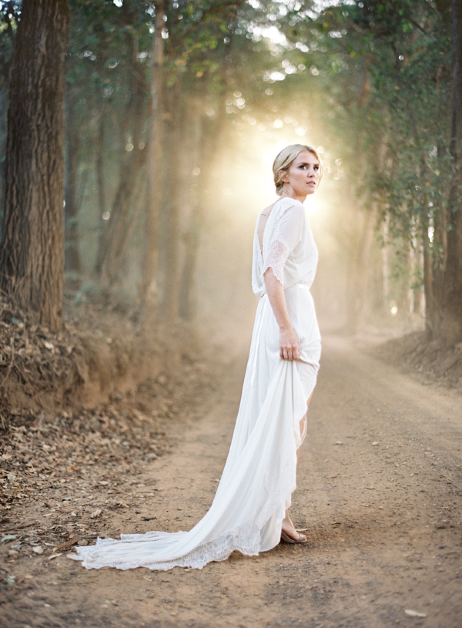 Bride on a sunlit woodland path