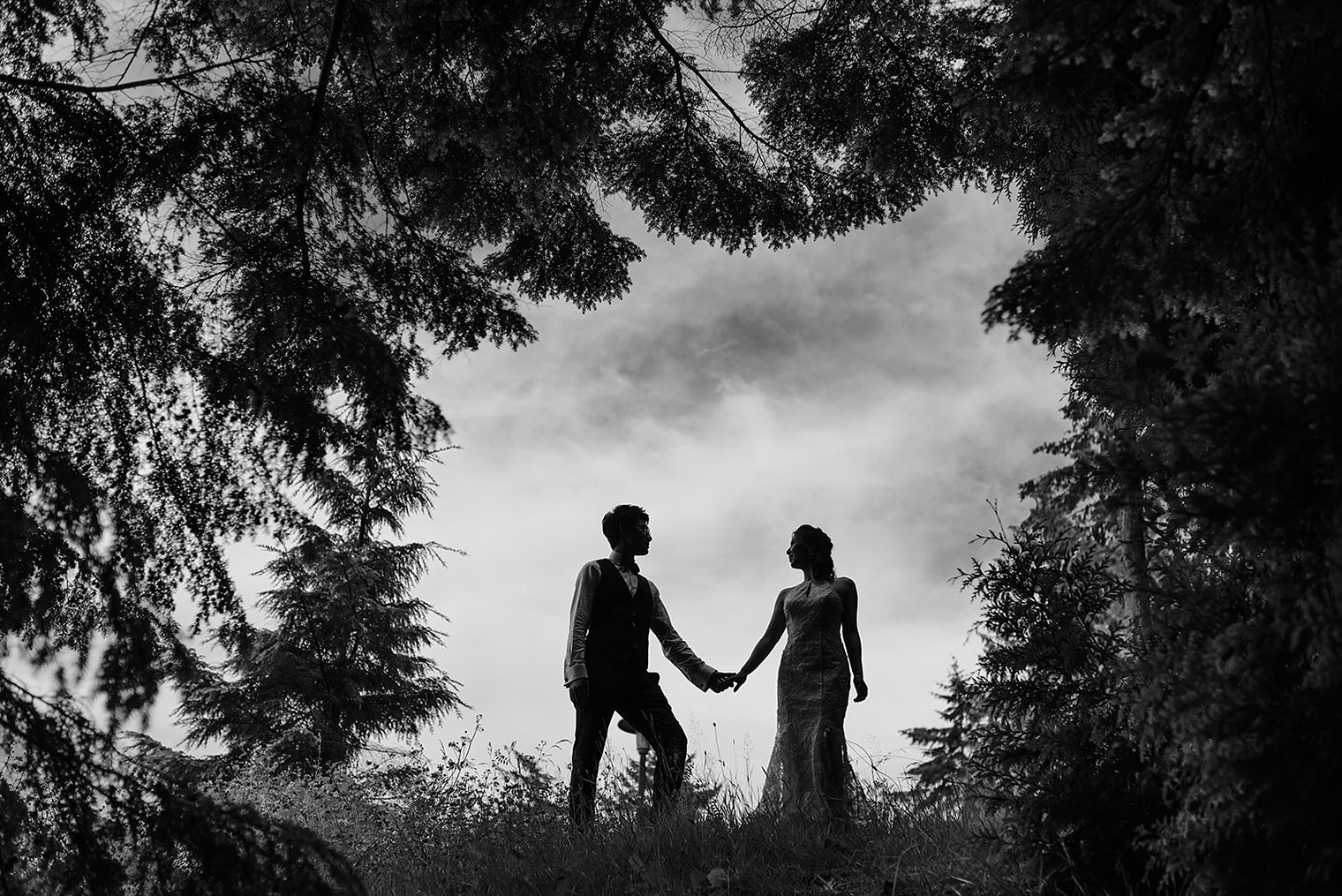 Wedding couple portrait on the oceanfront stone balustrade of Cecil Green Park House overlooking the Pacific at UBC Vancouver BC
