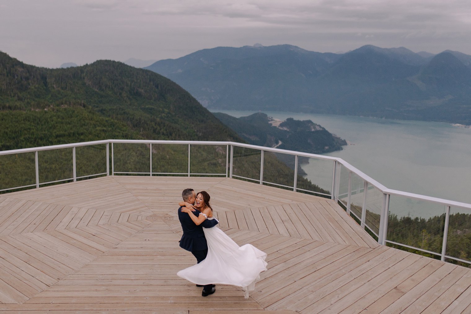 Couple exchanging elopement vows on high alpine granite ridge overlooking Howe Sound glacial fjord in Squamish BC