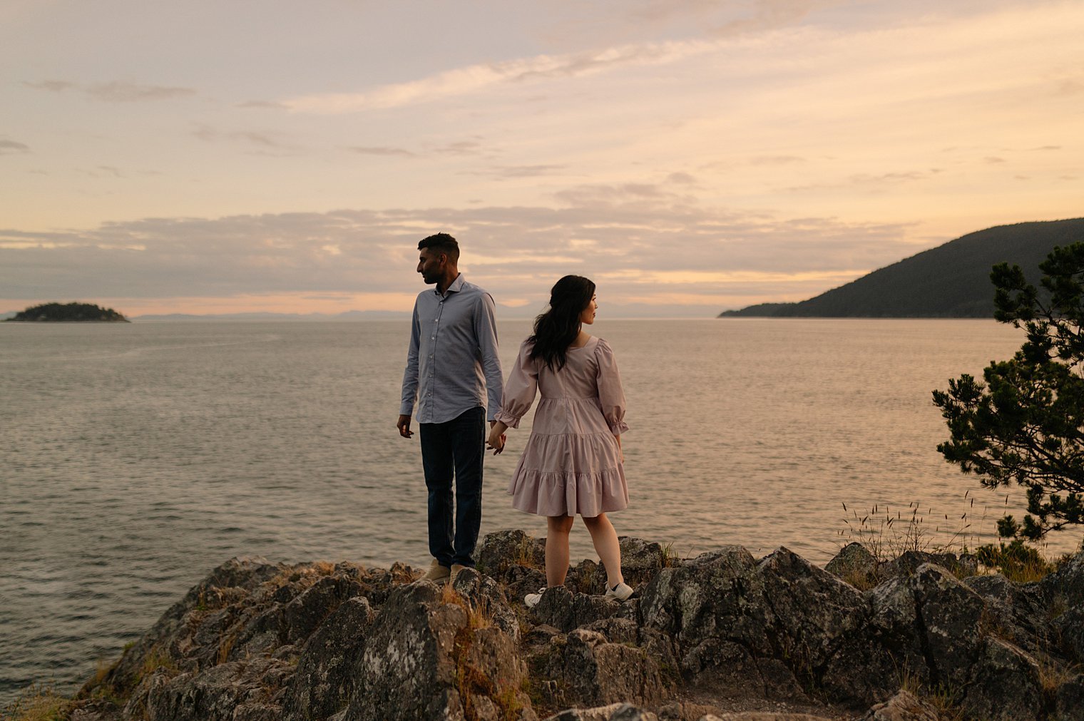 Elopement couple in quiet embrace on the sunset shoreline granite rocks of Whytecliff Park in West Vancouver BC